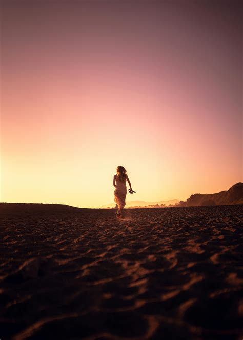 Woman Walking Alone On Beach