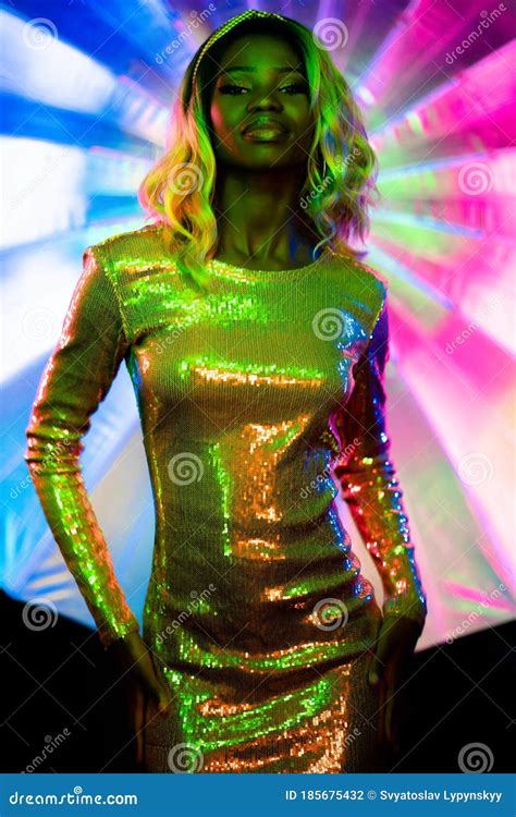 African Woman in Neon Glow. Dark Skinned Lady in Glittering Dress Poses Looking at Camera Stock ...
