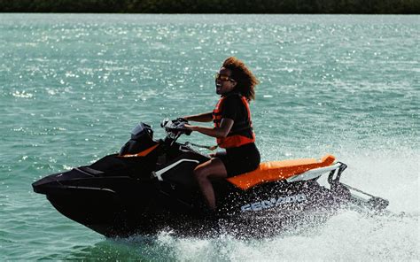 A woman performing a stunt on her Sea-Doo Spark with the words “Make Waves sales event”