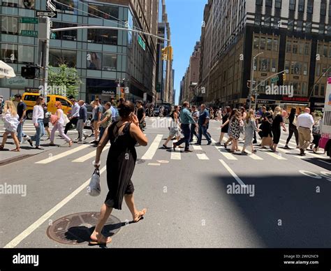 Pedestrians are surrounded by video billboards as they cross the street ...