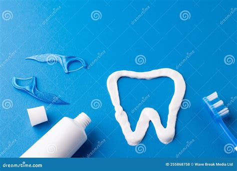 Image of Toothbrush, Toothpaste, Strings and Tooth Made of Paste on Blue Surface Stock Photo ...