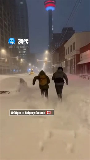 8:20pm in downtown Calgary, Canada 🇨🇦 What should have been a quiet winter night turned into a race against the storm. Heavy snow swept through the empty streets, erasing tire tracks and softening the city’s edges. Streetlights glowed dimly through the falling snow, casting long shadows across a downtown that felt suddenly unfamiliar. Two figures ran forward, hand in hand, pushing through knee-deep snow as wind howled between buildings. Each step was a struggle. Each breath visible in the cold