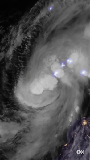Flashes of lightning punctuate Isaias' swirling clouds as it strengthens into the first Atlantic hurricane of the season. The northern Gulf Coast is alert for dangerous storm surge, damaging winds… | CNN