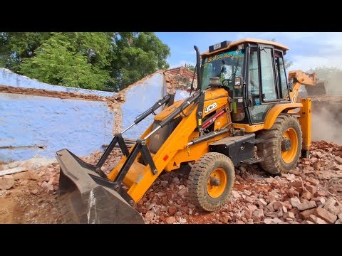 JCB 3DX is demolishing an old mud house, clearing out the wooden logs and timber, leveling the land