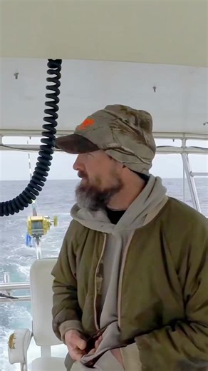 One crewmate surprises another with a birthday cake at sea