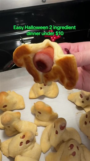 Spooky Ghost Dogs 1 pack of hot dogs 2 packs of crescent roll sheets - Cut hot dogs in half - Cut each pack of crescent roll sheets into 8 squares - Cover hot dog half with a crescent roll sheet and poke eye and mouth holes with a straw - Stand up on parchment lined cookie tray - Bake at 350 for 14 mins or until golden brown #halloweendinner #halloweendinnerideas #easydinnerideas #kidsdinnerideas #halloweenathome