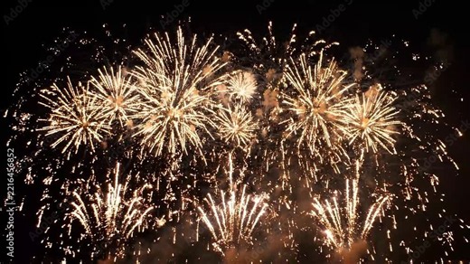 Spectacular golden fireworks explode in dark night sky over city skyline during celebration festival a dazzling display of light and color.