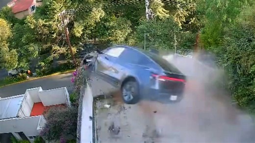 Tesla speeds through driveway and flies off ledge