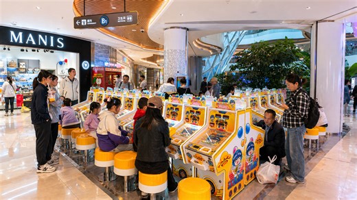 A busy shopping space where arcade games attract families and visitors