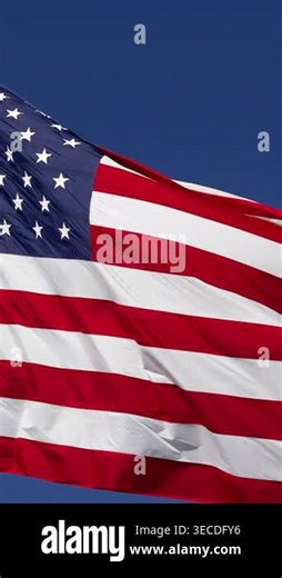 Vertical 4K slow motion American flag waving in the wind gracefully in close-up with bold red, white, & blue detail. Ideal for themes of patriotism, freedom, national pride, remembrance, government, military, holidays, and American identity Stock Video Footage - Alamy