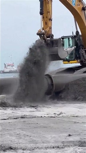 Lower the Iron into the Mud: A Crawler Crane Guides a Giant Pipe into the Tidal Flat