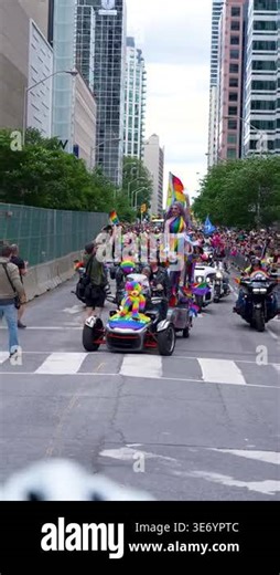 Street level view of a drag performer in a colorful outfit waving from a pride parade float decorated with rainbow flags and Canadian flag, surrounded by cheering spectators in downtown Toronto. Toronto, Canada - June 30, 2024 Stock Video Footage - Alamy