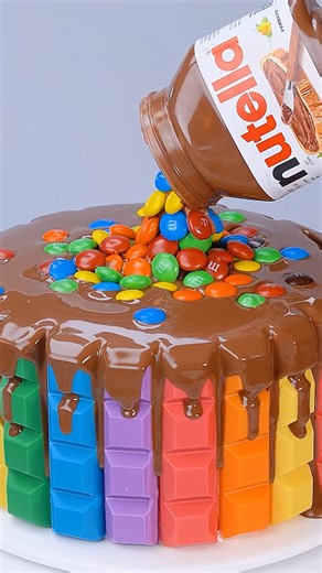 Colorful chocolate balls create a stunning rainbow cake design