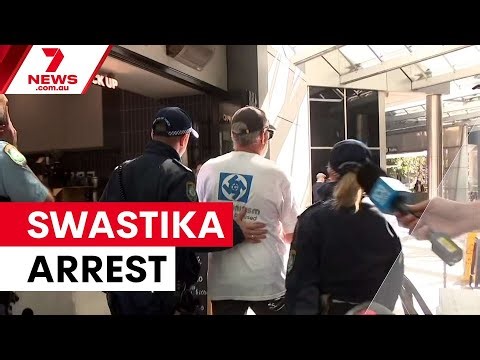 Man arrested for wearing swastika at antisemitism inquiry | 7NEWS