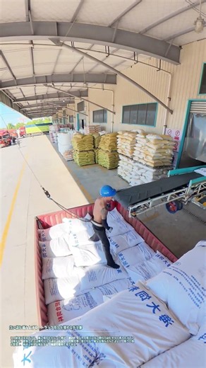 白い袋を積み上げる：トラック荷台を埋める手仕事