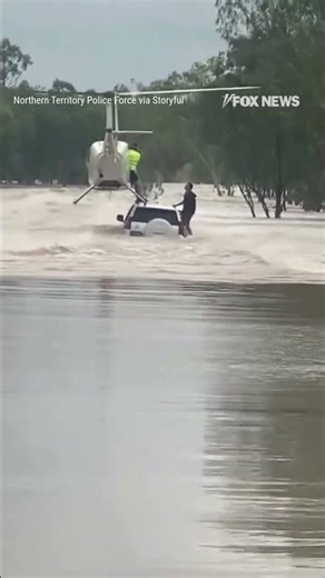 DARING RESCUE: Helicopter lands on flooded vehicle to rescue two men and a dog