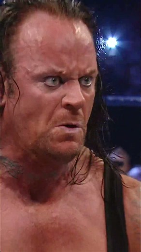 Undertaker swings for the fences and knocks Big Show out of the ring with a steel chair.