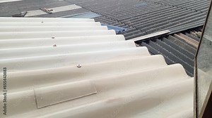 Hail falling on a tin roof viewed from a window during a cold rainy afternoon. Weather concept.