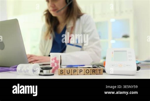Wooden blocks spell word Support near laptop and medical monitor on desk. Doctor woman types case notes coordinating remote follow up for patient Stock Video Footage - Alamy
