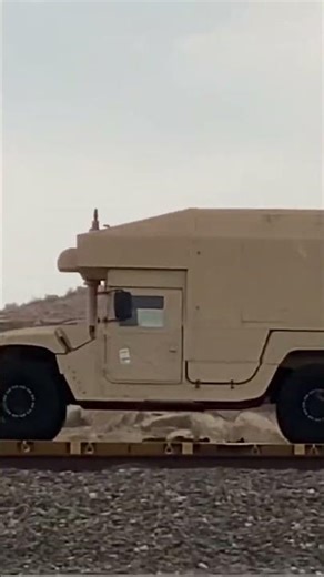Passing train loaded with military Humvee Vehicles with different equipment