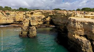 Natural arch above ocean, Arco de Albandeira, Algarve, Portugal. Stone arch at Praia de Albandeira, Lagoa, Algarve, Portugal. View of the natural arch Arco da Albandeira in the Algarve, Portugal.