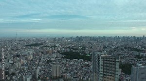 TOKYO, JAPAN : Aerial high angle sunset CITYSCAPE of TOKYO. View of buildings at central downtown area. Japanese city life and urban metropolis concept. Long time lapse zoom in shot dusk to night.
