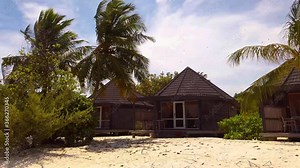 Small Chalet Houses on the Maldives. A little house surrounded by palm trees on white sandy beach