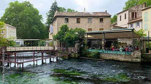 Fontaine de Vaucluse village with charming riverside in a picturesque town with colorful buildings during a peaceful afternoon. France, Provence, Vaucluse, Pays des Sorgues, Fontaine de Vaucluse.