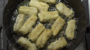 Making pan fried cod fish fillet in cast iron frying pan with cooking oil on gas stove. Stock Video