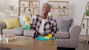 Wiping, table and portrait of a woman cleaning the living room for housework and chores. Happy, spraying and African girl with detergent, cloth and product to clean a desk with spray in the lounge