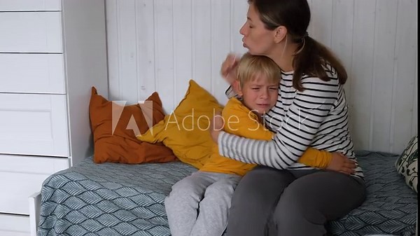 Crying, sad and tears of 6 years old boy with mom for comfort, safety while upset at home. Toddler child cry in arms of caring woman babysitter, nanny. Mother gently comforting her distressed kid