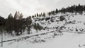 Drone shot - flying towards a rocky, snow-covered cliff in Eastern Washington near the Palouse