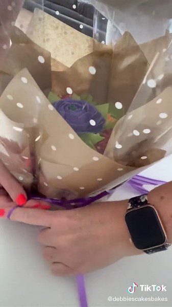 Let’s put together this seven cupcake bouquet - arranging the cups, inserting them, wrapping it up and the finished result! Gorgeous 🥰 #cupcakebouquet #cupcake #bouquet #cakehowto #debbiebakes #cakestuff #caketok #watchme #learncake #buttercreamflowersvideo #orangeflower #purpleflowers #💐 #flowers