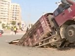Shocking CCTV shows overloaded truck fall into road hole