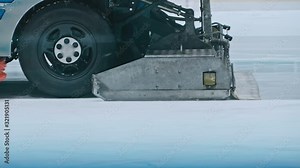Zamboni resurfacing an indoor skating rink. Slow Motion. Ice resurfacer cleaning ice, machine cleaning and polishing smooth icerink. Ice harvester or restores ice.