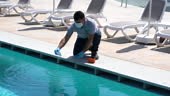Pool testing kit being used in a swimming pool