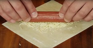 Il dépose des saucisses sur une pâte à egg roll et il crée un plat nouveau genre