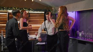 Beautiful young women and men dancing in nightclub, merry friends party in night . Happy people clubbing and resting in restaurant or trendy bar, have fun and joy, pastime and leisure in weekend