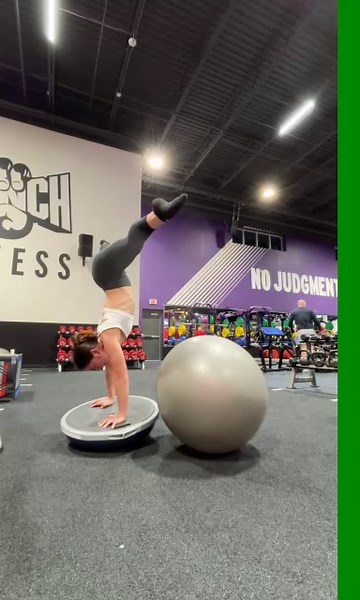 Woman Performs Handstand on Balance Ball Using Yoga Ball for Support