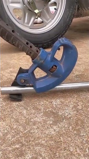 A manual pipe bender tool bending a metal pipe on the ground #construction #popular