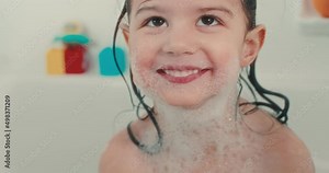 Cute toddler girl having a bubble bath. 4K cinematic footage.