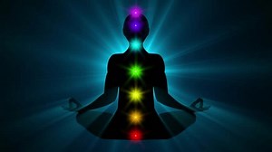 Silhouette of a person sitting in lotus yoga pose achieving nirvana or enlightenment | Unlocking Seven Chakras gaining Spiritual Awakening. Meditating human in lotus pose. Yoga seamless loop