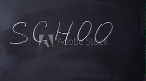 Bold white chalk letters spell School. Inscription SCHOOL. Chalk writing on blackboard. Concept of beginning of school year.