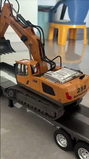 A yellow toy excavator, detailed with tracks and a digging arm.