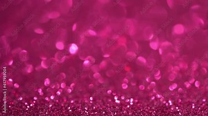 Abstract pink glitter background with moving and flicker particles. Magic dust, metallic sequins, shiny texture, holiday lights, flying particles form a beautiful bokeh. Shining Christmas backdrop
