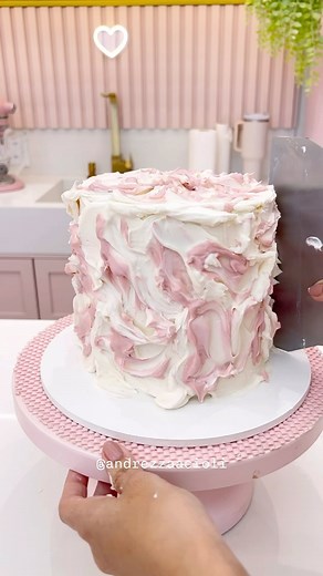 Andrezza Acioli ✨ Confeitaria ✨ Ganache Cake on Instagram: "Ganache cake marmorizado. 💖 Vem comigo que vou te mostrar como fazer essa decoração de bolo marmorizado, cheia de estilo! O processo é super simples: Comecei com uma base lisa, e depois fui mesclando a ganache rosa e branca, levei ao refrigerador para a ganache ficar firme, e depois com o auxílio de um soprador térmico fui aquecendo e retirando a ganache para aparecer esse efeito incrível ✨ e para finalizar adicinei uma plaquinha de ac
