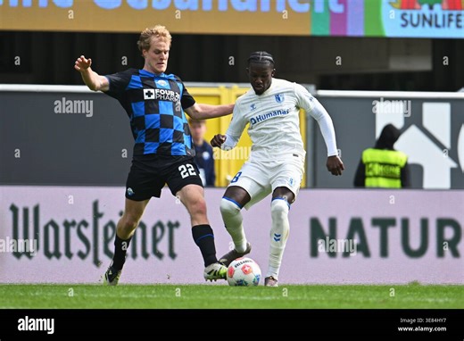 12 April 2026, North Rhine-Westphalia, Paderborn: Soccer, Men: Bundesliga 2, SC Paderborn 07 - 1. FC Magdeburg, Matchday 29, Home Deluxe Arena: Richmond Tachie (r, 1. FC Magdeburg) fights for the ball with Mattes Hansen (l, SC Paderborn 07). Photo: Swen Pförtner/dpa - IMPORTANT NOTE: In accordance with the regulations of the DFL German Football League and the DFB German Football Association, it is prohibited to utilize or have utilized photographs taken in the stadium and/or of the match in the 
