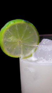 Download bartender Mixologist making a tasty alcoholic cocktail at the bar. the server is adding fresh natural ingredients to the liquor drink to stir gently. for free