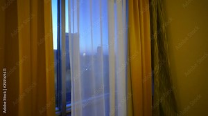Upper floor apartment or hotel room window with early morning city view. Steadicam POV shot