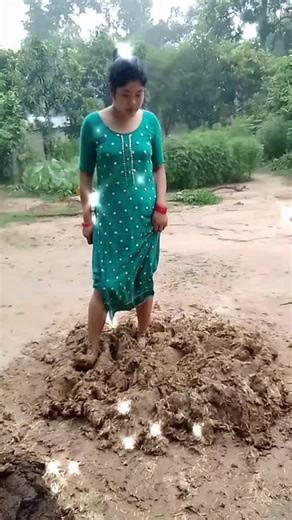 Woman in Green Dress Enjoys Outdoor Fun in Mud